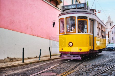 Foto de Famoso tranvía amarillo vintage 28 en las estrechas calles del distrito de Alfama en Lisboa, Portugal - símbolo de Lisboa, famoso destino turístico y atracción turística - Imagen libre de derechos