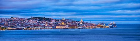 Téléchargez les photos : Vue de Lisbonne sur le Tage avec traversier d'Almada avec paquebot de croisière au crépuscule du soir. Lisbonne, Portugal - en image libre de droit