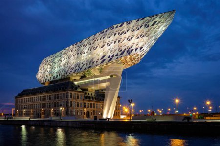 Foto de ANTWERP, BÉLGICA - 27 DE MAYO DE 2018: Casa de autoridad portuaria Porthuis diseñada por la famosa Zaha Hadid Architects que fue su último proyecto iluminado en la noche - Imagen libre de derechos
