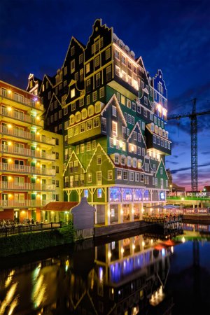 Téléchargez les photos : ZAANDAM, PAYS-BAS - 21 MAI 2018 : Inntel Hotel à Zaandam illuminé la nuit. La conception d'un bâtiment de 12 étages ouvert en 2009 est le résultat d'une série de maisons néerlandaises traditionnelles empilées - en image libre de droit