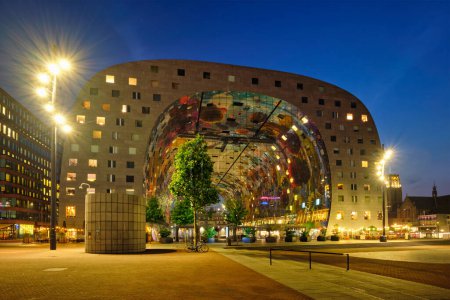 Téléchargez les photos : ROTTERDAM, PAYS-BAS - 25 MAI 2018 : Markthal Market Hall immeuble résidentiel et de bureaux avec une halle de marché en dessous à Rotterdam conçu par le cabinet d'architecture MVRDV illuminé dans la nuit - en image libre de droit