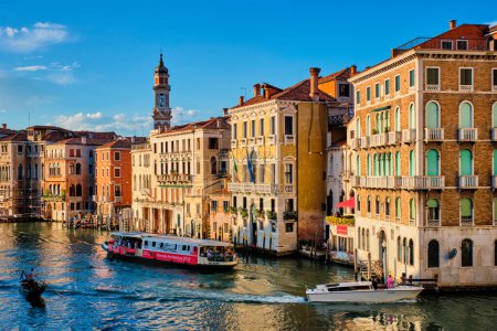 Foto de VENECIA, ITALIA - 27 DE JUNIO DE 2018: Gran Canal con barcos, vaporetto y góndolas al atardecer desde el puente de Rialto, Venecia, Italia - Imagen libre de derechos