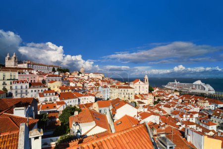 Photo for View of Lisbon famous postcard view from Miradouro de Santa Luzia tourist viewpoint over Alfama old city district, moored cruise liner and moving clouds. Lisbon, Portugal - Royalty Free Image