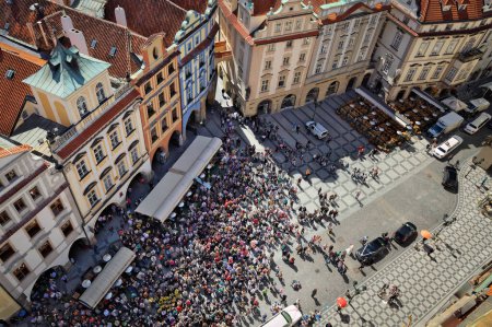 Foto de PRAUGE, REPÚBLICA CHECA - 26 DE ABRIL DE 2012: Multitud turística observando el reloj astronómico de Praga figuras animadas movimiento por hora en la Plaza de la Ciudad Vieja - Imagen libre de derechos