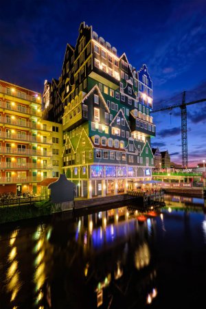 Photo for ZAANDAM, NETHERLANDS - MAY 21, 2018: Inntel Hotel in Zaandam illuminated at night. Design of 12-storey tall building opened in 2009 is the result of stacking a series of traditional Dutch houses - Royalty Free Image