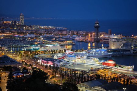 Téléchargez les photos : Barcelone, Espagne - 15 avril 2019 : Vue aérienne de l'horizon de la ville de Barcelone avec le trafic de la ville et le port avec des yachts et des ferries illuminés dans la nuit. Barcelone, Espagne - en image libre de droit