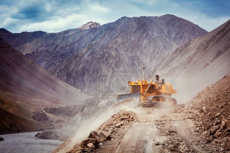 Photo for LADAKH, INDIA - SEPTEMBER 10, 2011: Bulldozer cleaning road after landslide in Himalayas. Ladakh, Jammu and Kashmir, India - Royalty Free Image