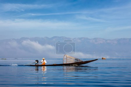 Photo for Myanmar travel attraction landmark - Traditional Burmese fisherman with fishing net at Inle lake in speeding motor boat - Royalty Free Image