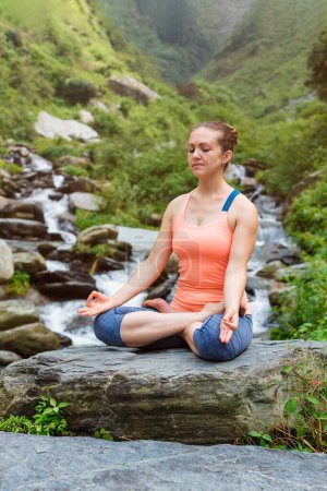 Photo for Woman in Hatha yoga asana Padmasana outdoors at tropical waterfall - Royalty Free Image