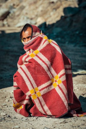 Téléchargez les photos : SARCHU, INDE - 2 SEPTEMBRE 2011 : Un Indien étouffé dans une couverture le matin froid sur la route Manali-Leh dans l'Himalaya au Ladakh, en Inde - en image libre de droit