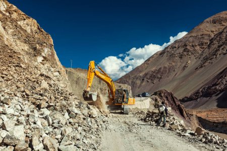 Photo for LADAKH, INDIA - SEPTEMBER 10, 2011: Excavator cleaning road after landslide in Himalayas. Ladakh, Jammu and Kashmir, India - Royalty Free Image