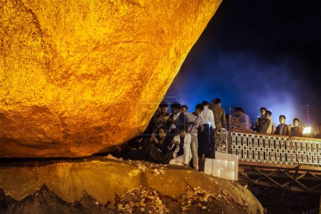 Téléchargez les photos : KYAIKTIYO, MYANMAR - 4 JANVIER 2014 : Personnes adorant à Golden Rock - Pagode Kyaiktiyo - célèbre monument du Myanmar, site de pèlerinage bouddhiste et attraction touristique, Myanmar - en image libre de droit