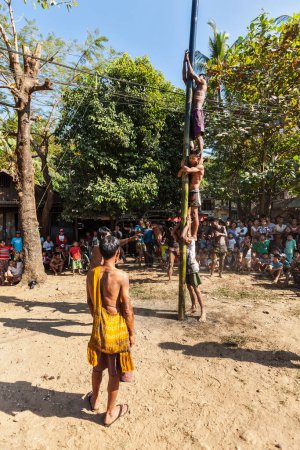 Téléchargez les photos : MYANMAR - 4 JANVIER 2014 : Compétition d'escalade de pôles graisseux dans un village le jour de l'indépendance du Myanmar - en image libre de droit