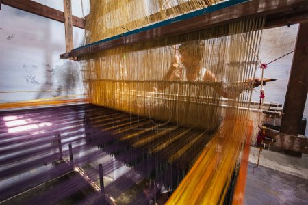 Photo for KANCHIPURAM, INDIA - SEPTEMBER 12, 2009: Man weaving silk sari on loom. Kanchipuram is famous for hand woven silk sarees and most of the city's workforce is involved in weaving industry - Royalty Free Image