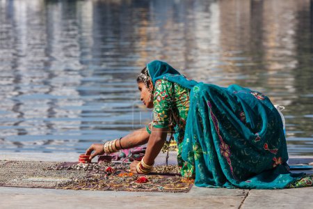 Photo for UDAIPUR, INDIA - NOVEMBER 24, 2012: Indian woman in Rajasthani traditional clothing selling jewellery on ghat of Lake Pichola, Udaipur, Rajasthan, India - Royalty Free Image