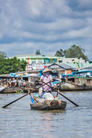 Foto de CAN THO, VIETNAM - 4 DE JUNIO DE 2011: Mujer no identificada en el mercado flotante del delta del río Mekong. Los mercados Cai Rang y Cai Be son mercados centrales en el delta y se convirtieron en un popular destino turístico. - Imagen libre de derechos