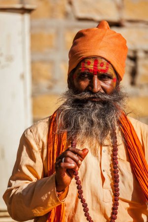 Foto de JAISALMER, INDIA - 28 de noviembre de 2012: Bendición del sadhu indio (hombre santo). Los Sadhus son hombres santos que viven la vida ascética y se centran en la práctica espiritual del hinduismo - Imagen libre de derechos