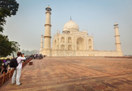 Foto de AGRA, INDIA - 17 DE NOVIEMBRE DE 2012: Turista tomando fotos de Taj Mahal famoso monumento indio y atracción turística, Patrimonio de la Humanidad por la UNESCO y considerado uno de los edificios más bellos del mundo - Imagen libre de derechos