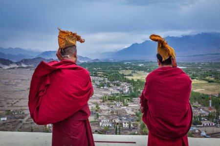 Photo for THIKSEY, INDIA - SEPTEMBER 4, 2011: Two Tibetan Buddhist monks blowing conches during morning pooja, Thiksey gompa, Ladakh, India - Royalty Free Image