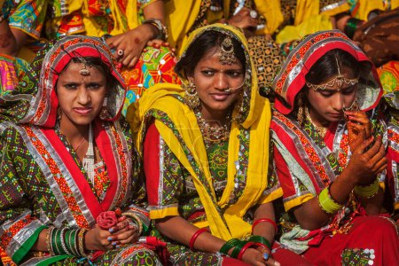 Foto de PUSHKAR, INDIA - 21 DE NOVIEMBRE DE 2012: Chicas no identificadas de Rajasthani con trajes tradicionales se preparan para la perfomance de la danza en la feria anual de camellos Pushkar Mela en Pushkar, Rajastán, India - Imagen libre de derechos