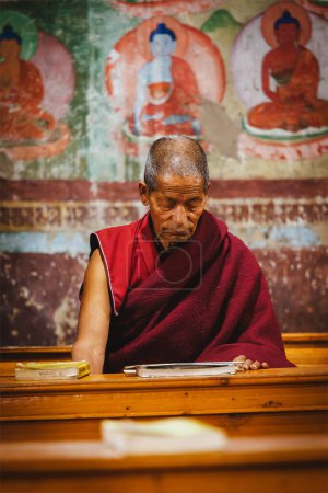 Photo for THIKSEY, INDIA - SEPTEMBER 4, 2011: Old Tibetan Buddhist monk during prayer in Thiksey gompa (Buddhist monastery) of the Yellow Hat (Gelugpa) sect - the largest gompa in central Ladakh - Royalty Free Image