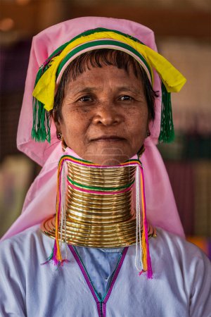 Foto de INLE LAKE, MYANMAR - 7 DE ENERO DE 2014: Mujer de la tribu Padaung de cuello largo. Las mujeres de la tribu Padaung de cuello largo usan anillos de bronce alrededor del cuello a partir de los 5 años de edad y la minoría explotada por razones de turismo. - Imagen libre de derechos