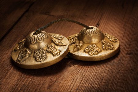 Photo for Tibetan Buddhist tingsha cymbals on wooden background - Royalty Free Image
