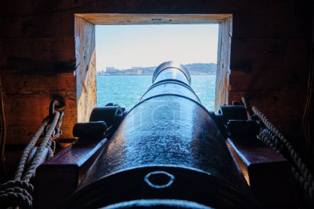 Foto de Vista al mar desde un puerto de artillería sobre el cañón cañón de cañón en la cubierta de un barco de vela Age of Sail - Imagen libre de derechos