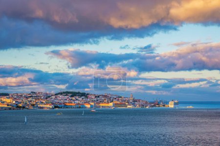 Foto de Vista de Lisboa sobre el río Tajo desde Almada con yates barcos turísticos y crucero amarrado en el atardecer con cielo dramático. Lisboa, Portugal - Imagen libre de derechos