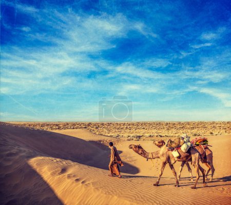 Foto de Imagen de viaje de estilo hipster retro vintage del fondo de viaje de Rajastán: camello de la India (conductor de camello) con camellos en las dunas del desierto de Thar con textura grunge superpuesta. Jaisalmer, Rajastán, India - Imagen libre de derechos
