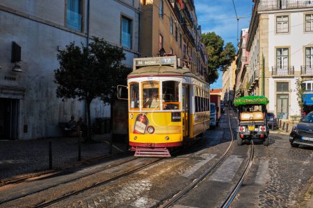 Photo for Lisbon, Portugal - September 1, 2022: Famous vintage yellow tram in the narrow streets of Alfama district in Lisbon, Portugal - symbol of Lisbon, famous popular travel tourist attraction - Royalty Free Image