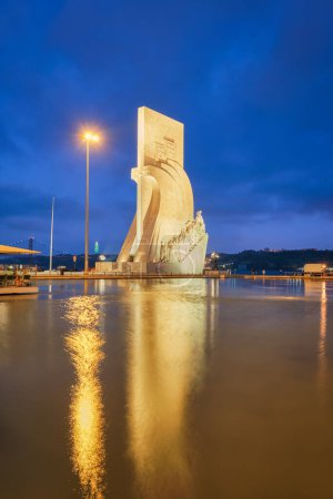 Foto de Lisboa, Portugal - 26 de agosto de 2022: Monumento a los Descubrimientos a orillas del río Tajo en el crepúsculo de la tarde con reflexión en la piscina de agua, Lisboa, Portugal, Europa - Imagen libre de derechos