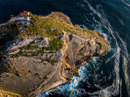 Téléchargez les photos : Vue aérienne du cap Espichel de Cabo Espichel sur l'océan Atlantique au coucher du soleil avec des ruines - en image libre de droit
