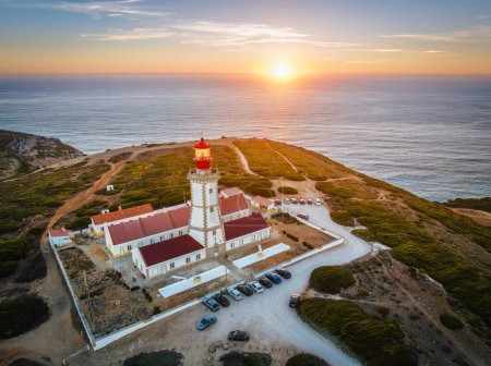 Photo for Aerial drone view of lighthouse on Cabo Espichel cape Espichel on Atlantic ocean at sunset. Sesimbra, Portugal - Royalty Free Image