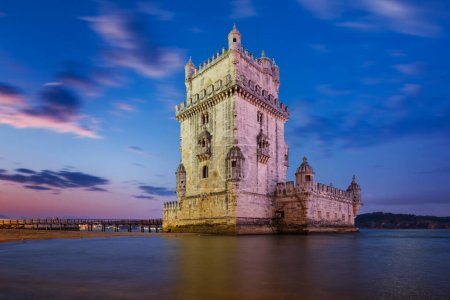 Belem Tower or Tower of St Vincent - famous tourist landmark of Lisboa and tourism attraction - on the bank of the Tagus River Tejo after sunset in dusk twilight with dramatic sky. Lisbon, Portugal