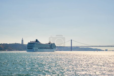 Photo for Lisbon, Portugal - August 31, 2022: MSC Orchestra cruise ship of Musica class in Tagus river with the 25 de Abril Bridge in the background. She could accommodate 2550 passengers in 1275 cabins - Royalty Free Image