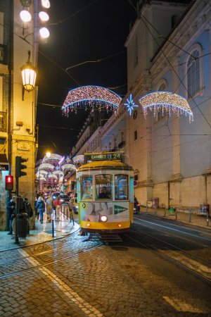 Photo for Lisbon, Portugal - December 9, 2022: Vintage old tram in Lisbon street decorated for Christmas in the evening - Royalty Free Image