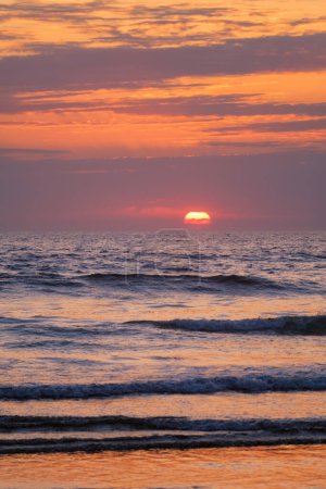 Téléchargez les photos : Vagues océaniques au coucher du soleil avec fond de soleil couchant - en image libre de droit