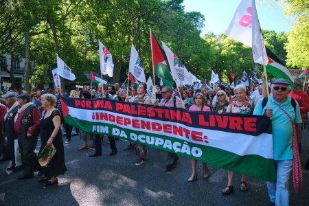Photo for Lisbon, Portugal - April 25, 2023: Anniversary celebration of The Carnation Revolution aka the 25 April Revolution 25 de Abril by demonstration march with Free Palestine placard - Royalty Free Image