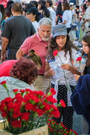 Photo for Lisbon, Portugal - April 25, 2023: People buying carnations at anniversary celebration of The Carnation Revolution aka the 25 April Revolution 25 de Abril by demonstration march - Royalty Free Image