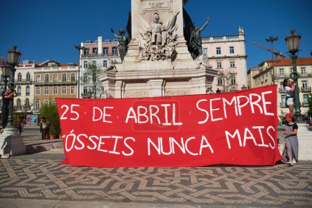 Photo for Lisbon, Portugal - April 25, 2023: Environmental activism streamer flag Anniversary celebration of The Carnation Revolution aka the 25 April Revolution 25 de Abril by demonstration march - Royalty Free Image