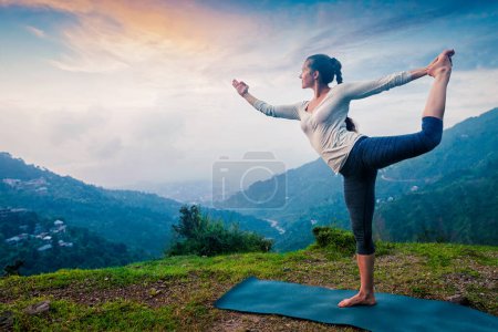 Foto de Mujer haciendo yoga asana Natarajasana - Señor de la danza posan al aire libre en cascada en Himalaya - Imagen libre de derechos