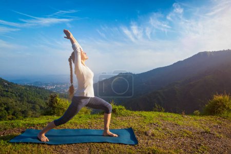 Photo for Yoga outdoors - woman doing yoga asana Virabhadrasana 1 - Warrior pose posture outdoors in Himalayas mountains in the morning - Royalty Free Image