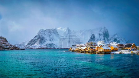 Panorama of yellow rorbu houses of Sakrisoy fishing village with snow in winter. Lofoten islands, Norway