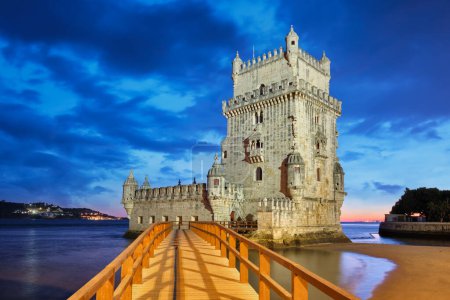 Belem Tower oder Turm von St. Vincent - berühmtes touristisches Wahrzeichen von Lissabon und Touristenattraktion - am Ufer des Tejo (Tejo) nach Sonnenuntergang in der Abenddämmerung mit dramatischem Himmel. Lissabon, Portugal
