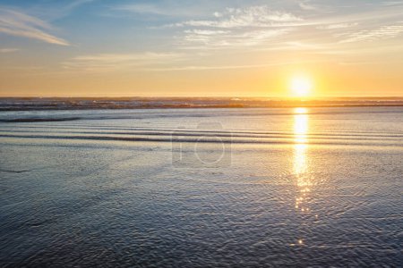 Foto de Puesta de sol en el océano Atlántico con olas crecientes en la playa de Fonte da Telha, Costa da Caparica, Portugal - Imagen libre de derechos