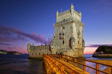 Foto de Torre Belem o Torre de San Vicente famoso monumento turístico de Lisboa y la atracción turística a orillas del río Tajo (Tejo) después de la puesta del sol en el crepúsculo con el cielo dramático. Lisboa, Portugal - Imagen libre de derechos