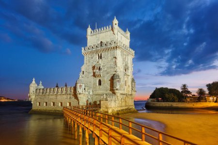 Belem Tower oder Turm von St. Vincent - berühmtes touristisches Wahrzeichen von Lissabon und Touristenattraktion - am Ufer des Tejo (Tejo) nach Sonnenuntergang in der Abenddämmerung mit dramatischem Himmel. Lissabon, Portugal