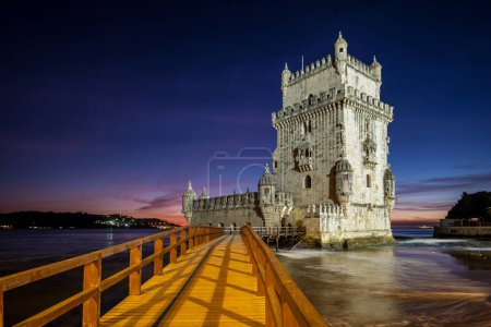 Torre Belem o Torre de San Vicente - famoso monumento turístico de Lisboa y atracción turística - en la orilla del río Tajo (Tejo) después de la puesta del sol en el crepúsculo del atardecer con el cielo dramático. Lisboa, Portugal