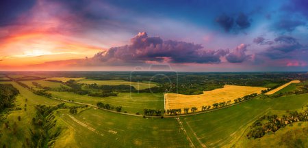 Ukraina. Wiejski letni krajobraz zachodu słońca z zielonymi polami i dramatycznym kolorowym niebem, naturalnym tłem, panoramą z lotu ptaka. Obwód kijowski